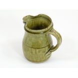 RICHARD BATTERHAM. A ¼ pint jug with olive green glaze by Richard Batterham. Height 11cm.