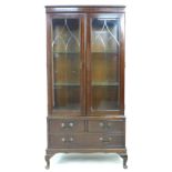 A mid 20th century mahogany display cabinet, with two astragal glazed doors enclosing two glass