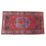 A Hamadan rug on red ground, blue central lozenge with sawtooth edging, with a blue star design