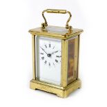 A modern brass carriage clock, with five glass case, the white enamel dial with black Roman