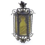 A 20th century wrought iron hanging porch lantern, of hexagonal form, decorated with scroll and