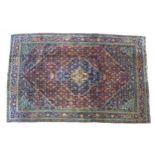 A Kashan rug with red ground, central dark blue and cream floral medallion with pendant anchors,