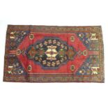 A Hamadan rug with red ground, large central medallion on black ground with dark blue saw-tooth