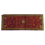 A Karajeh runner with red ground, densely decorated field and multiple borders, 147 by 58cm.