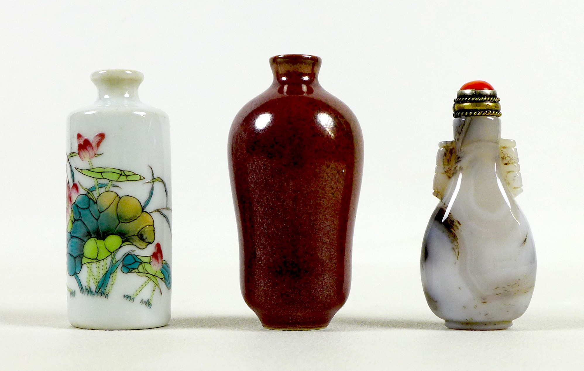 A group of three Chinese miniature bottles, comprising a carved hardstone scent bottle, 7cm high,