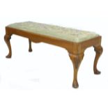 A mid 20th century walnut veneered footstool, the rectangular seat embroidered with flowers,