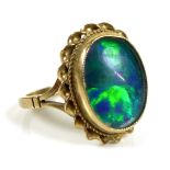 A 9ct gold and blue opal ring, the central stone of approximately 1.9 by 1.5cm within a rope twist