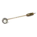 A yellow metal stick pin, the removable head set with a cultured pearl surrounded by ten diamonds,