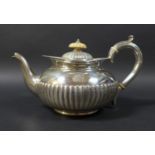 A Victorian silver teapot, with a bone finial, half gadrooned decoration to its lid and base, an