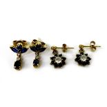 Two pairs of gold and sapphire drop stud earrings, the first of flowerhead design with central white