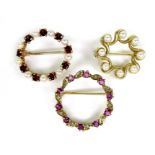 A group of three 9ct gold wreath brooches, one set with garnets and pearls, 2.3cm, the second set
