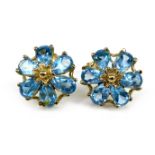 A pair of 9ct gold and blue topaz flowerhead stud earrings, 1.1cm diameter, 2.1g.