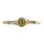 A 15ct gold, peridot and pearl open bar brooch, the central stone of 0.5cm diameter and surrounded