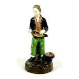 A late 18th century porcelain figure, possibly Derby, modelled as a man playing a hurdy-gurdy,