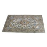 A Kashan rug with cream ground, central caucasian and cream floral medallion with pendant anchors,