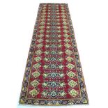 A Hamadan runner with red ground, decorated with a repeat pattern of floral motifs, two narrow cream