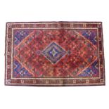 A Meimeh rug with red ground, a dark blue central stepped diamond with pendent anchors, with a