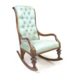 A Victorian mahogany rocking chair, upholstered in button back fabric, with carved decoration to the