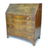 A George III oak bureau, fall front with fitted interior, four graduating drawers with brass plate