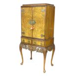 A late 20th century cocktail cabinet, with walnut veneers, oriental style brass fittings, a mirror