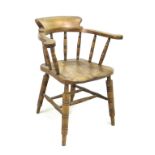 A 19th century oak smokers bow armchair, with stamped maker's mark 'Elliot & Sons JJH', raised on