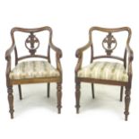 A pair of Regency mahogany open arm chairs, with Prince of Wales feathers to the splat, shaped