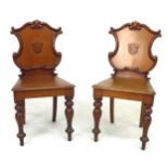 A pair of Oak hall chairs, with shield backs, turned front legs and sabred back legs, 46 by 47 by