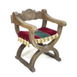 A carved work curule open armchair with upholstered seat, 62 by 54 by 75cm high.