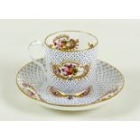 An Edwardian Coalport china cabinet cup and saucer, decorated with sprays of flowers with gilt