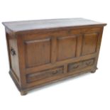 An 18th century oak mule chest, with three carved panels to the front, over two drawers, raised on