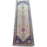 An Abadeh runner on dark blue ground with large cream central medallion, containing three small