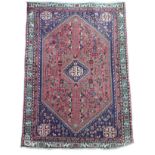 An Abadeh rug with dark blue ground, with large pink central hexagonal panel containing a blue and