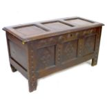 A 17th century oak chest, lift top over a three panel front carved with diamonds and lunettes,