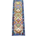 A Chobi Kilim runner, decorated with a row of seven lozenges across its center, 196 by 61cm.