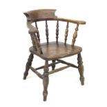 A 19th century oak smokers bow armchair, with stamped maker's mark 'Johnson Holland & Co, Wycombe,