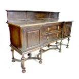 An Edwardian oak sideboard, two central drawers flanked by two cupboards, brass drop handles,