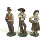 A group of three early to mid 20th century Portuguese terracotta figures, modelled as a fisher-women