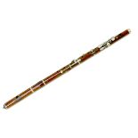 A late 19th/early 20th century rosewood flute, three sections with white metal mounts and keys,