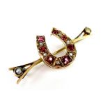 A Victorian rose gold, ruby diamond and pearl horseshoe brooch, set with seven rubies of graduated