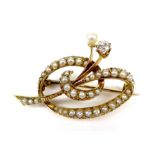 A 15ct gold, diamond and pearl brooch, the scrolling body set with a row of seed pearls, and a