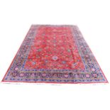 A Sarough rug, with floral design across central red ground and dark blue ground borders, 350 by
