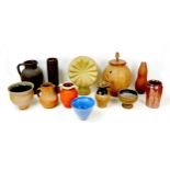 A collection of stoneware vessels and other decorative pieces, including a circular form ornament,