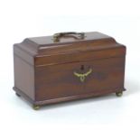 A Georgian mahogany tea caddy, with grass fittings and three compartments to its interior, raised