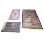 A group of three rugs, one a small Tekke rug with with five medallions on pink ground, 130 by