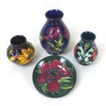 A group of four pieces of Moorcroft pottery, comprising a baluster vase, 9 by 13cm high, two spill