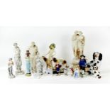 A group of porcelain and plaster figurines, including a Meissen style figural group of a cherub with