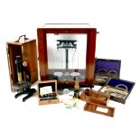 A group of scientific instruments, including a vintage set of Baird & Tatlock laboratory scales,