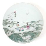 A Chinese porcelain charger, 19th century, decorated in famille verte palette with two ladies