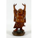 A Chinese carved wooden figure of a Buddha, modelled standing with his arms raised, on a turned