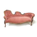 A Victorian walnut framed settee, covered in a pink button back dralon fabric, raised on cabriole